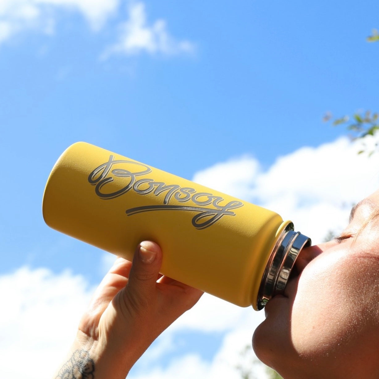 Drinking from yellow stainless steel water bottle