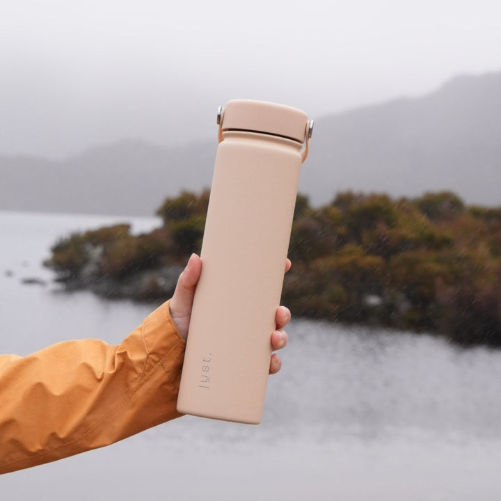 hand holding beige water bottle 