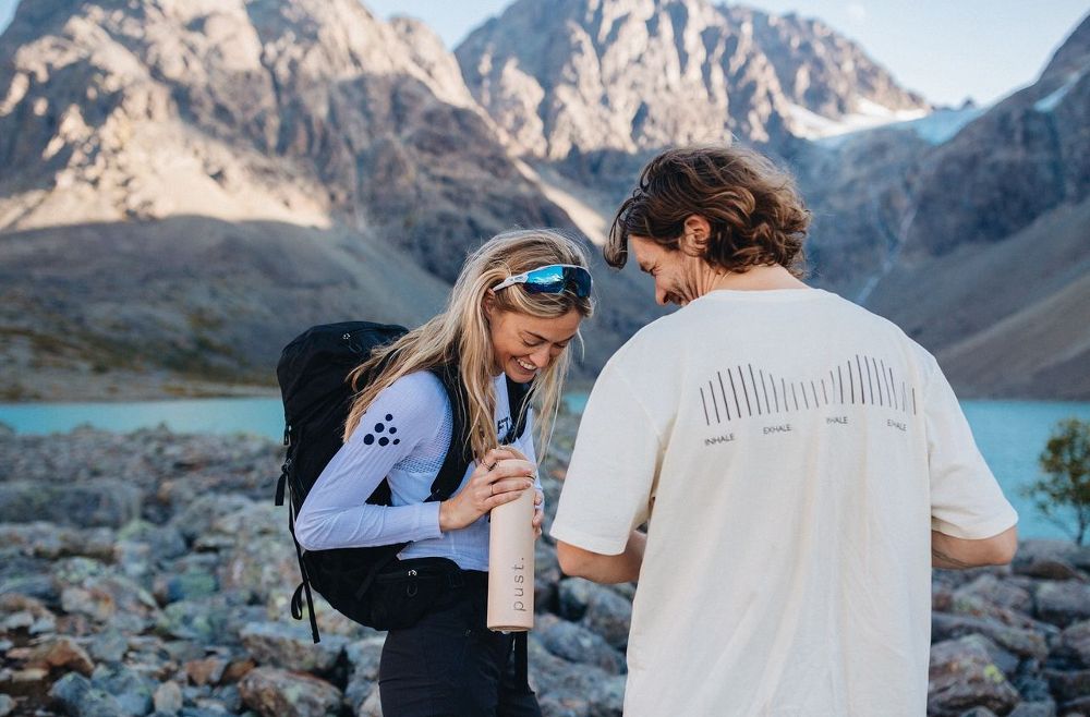 person holding a custom water bottle while hiking