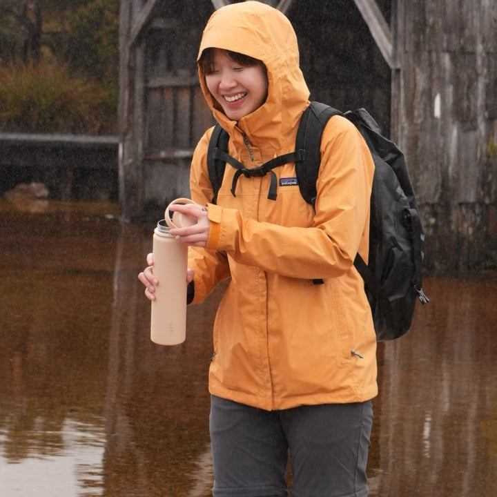 Women holding beige water bottle 