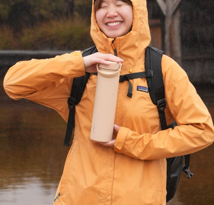 Women holding beige water bottle 